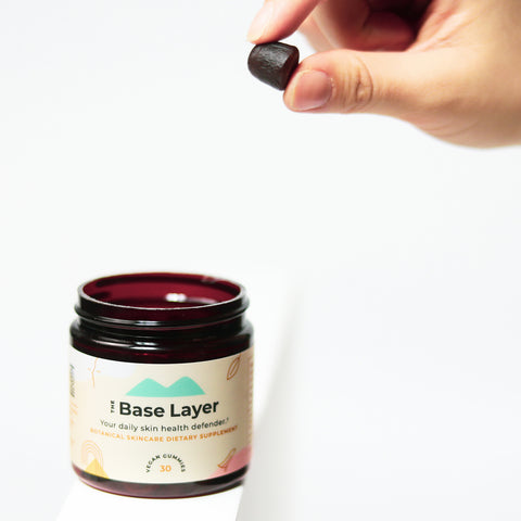 Hand holding Sundaily Base Layer gummies