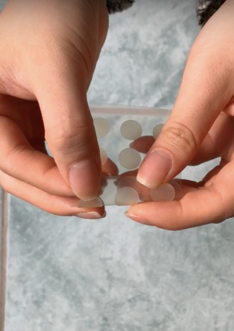 Image of hands peeling off Mighty patch